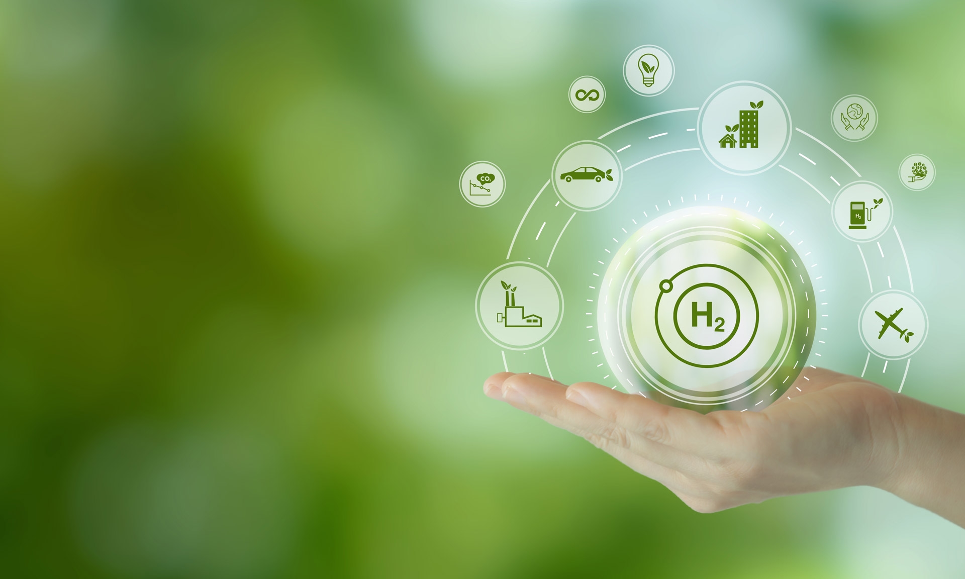 Hand holding hydrogen icon surrounded by symbols of sustainable energy and technology on a green background.